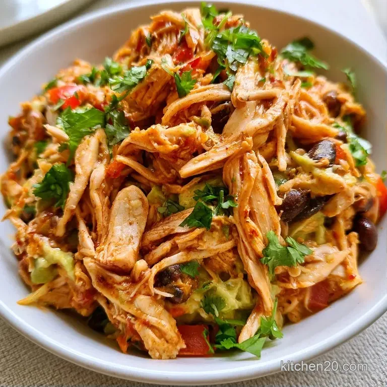 Vibrant bowl of seasoned meat, golden corn, and creamy avocado slices topped with fresh cilantro and lime wedges.