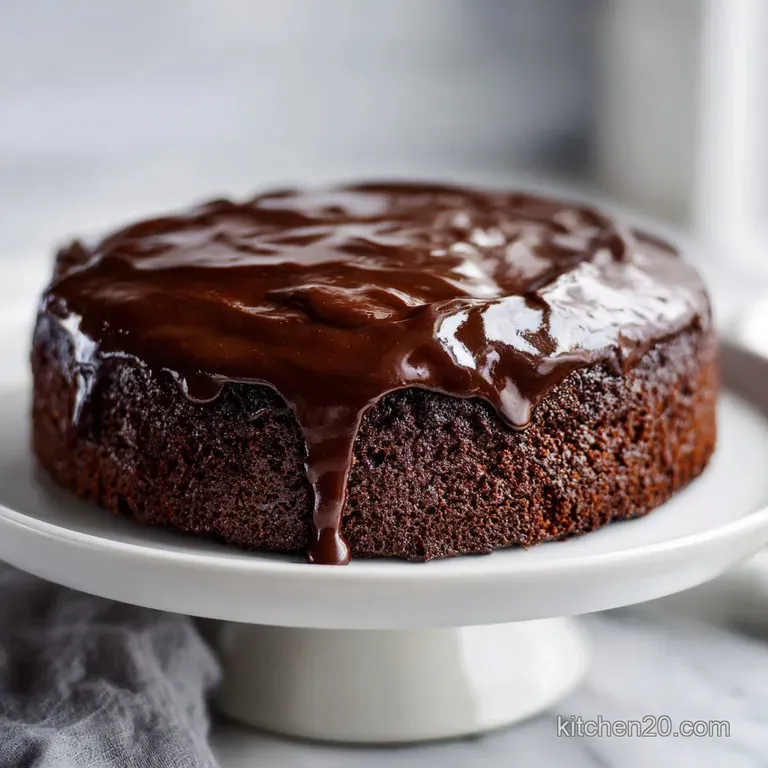 Slice of light and airy cake, drizzled with caramel and chocolate, resting on a white plate with a fork alongside.